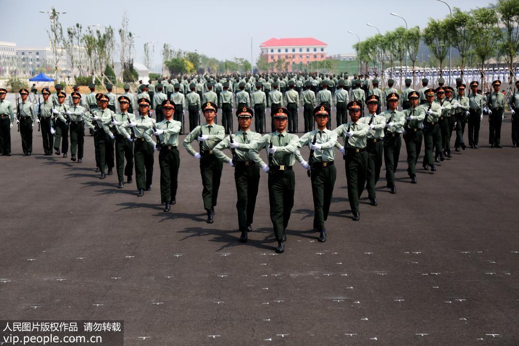 教练员运用多种方式为参训官兵纠正动作。白栋人民图片