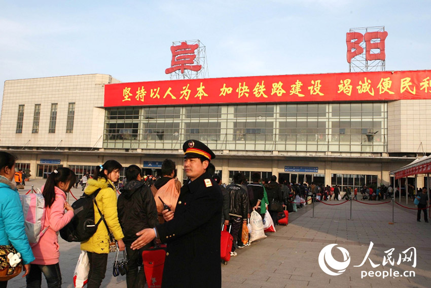 阜阳站客运人员在春运现场引导旅客有序进站上车。
