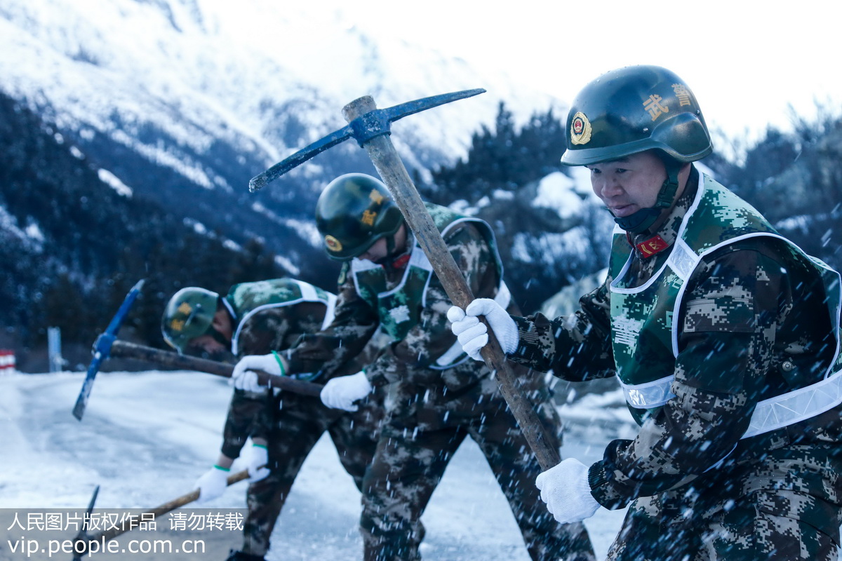 1月14日，武警官兵在清理川藏公路然乌湖段路面结冰。