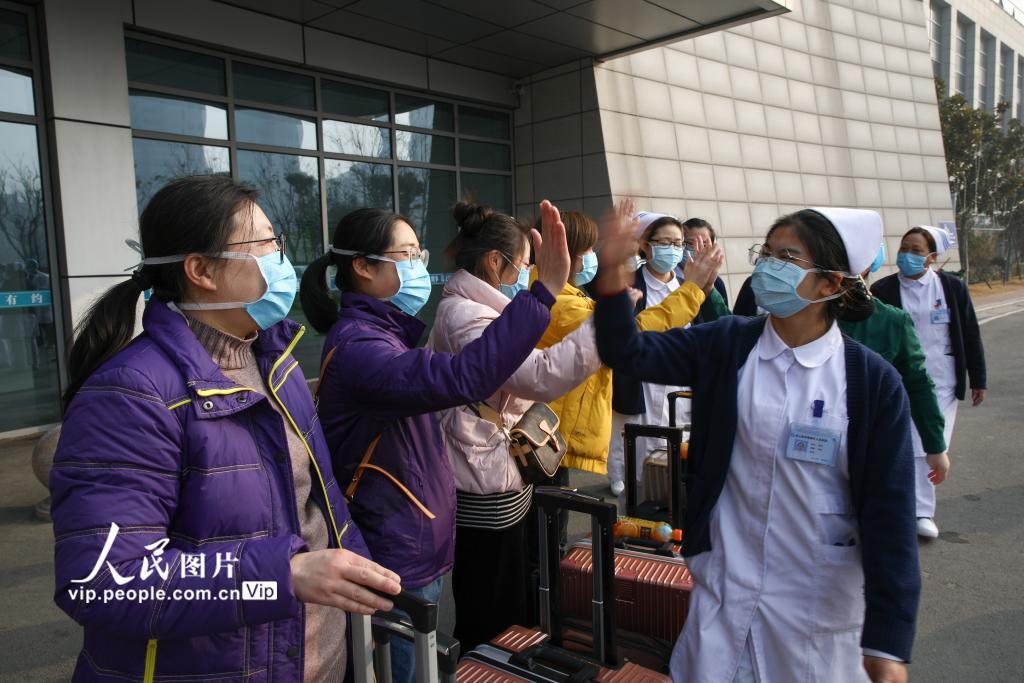 2月2日，在江苏省连云港市赣榆区人民医院驰援武汉医疗护理队队员出发前与送行人员击掌告别。（司伟 人民图片）