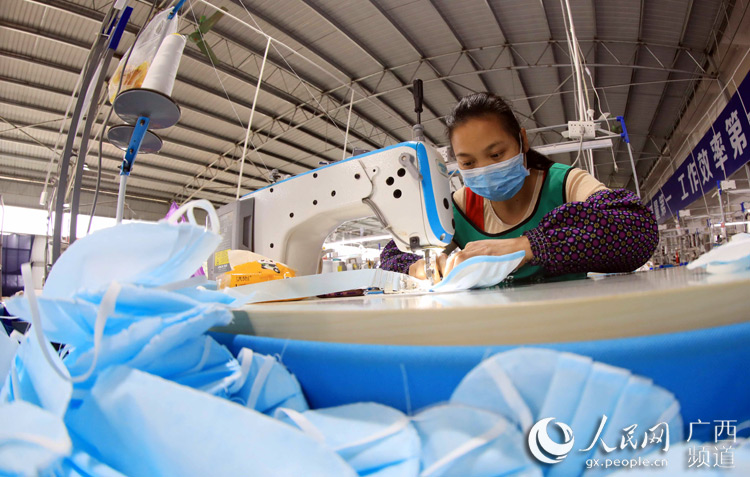 一名女工在扶贫微车间普通民用口罩生产线上作业。谭凯兴摄