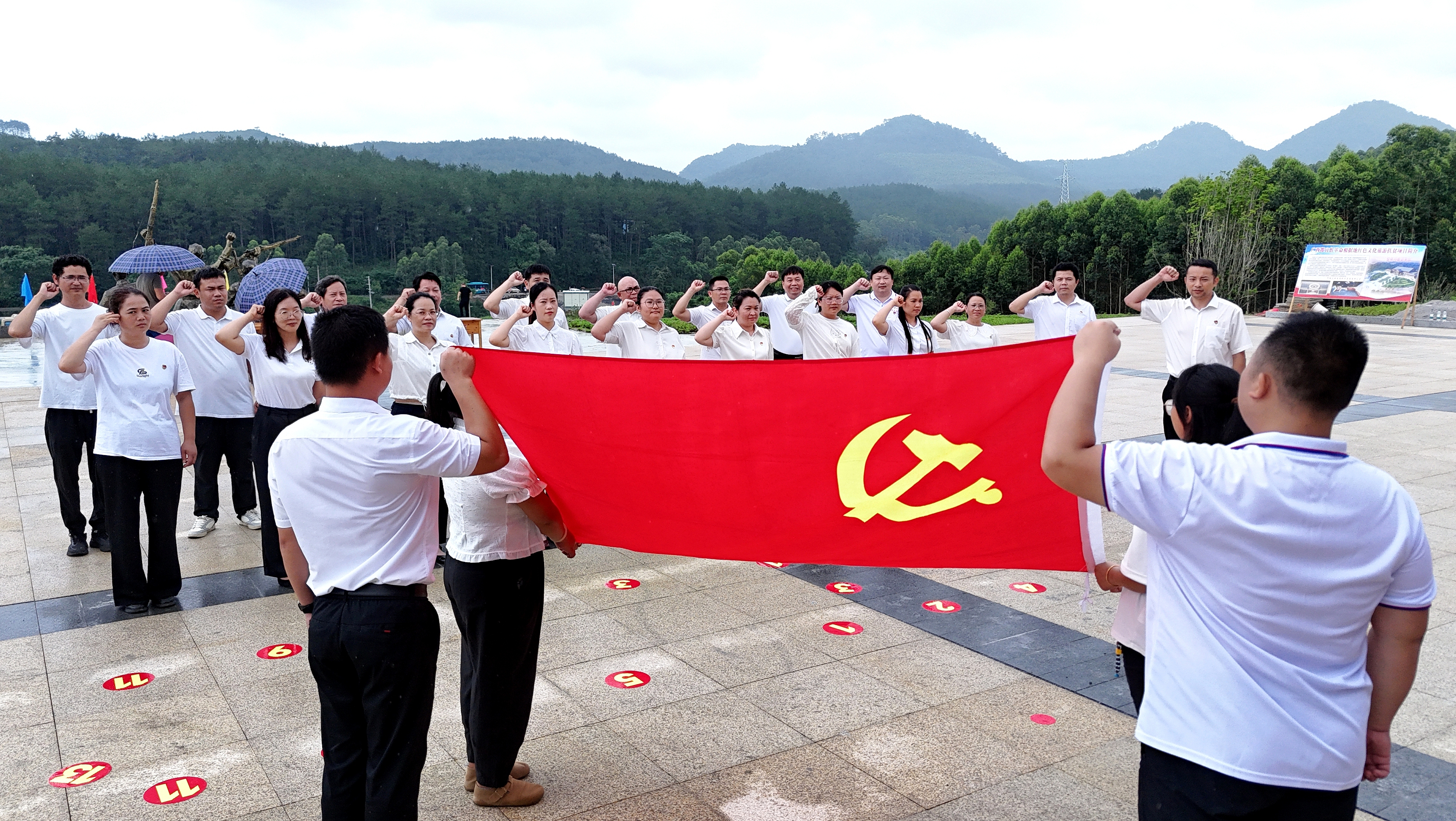 2025年7月1日，廣西都宜忻人民解放總隊紀(jì)念館前，黨員面向黨旗重溫入黨誓詞。