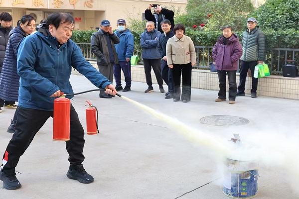 离退休党员在专业人员指导下进行消防实操