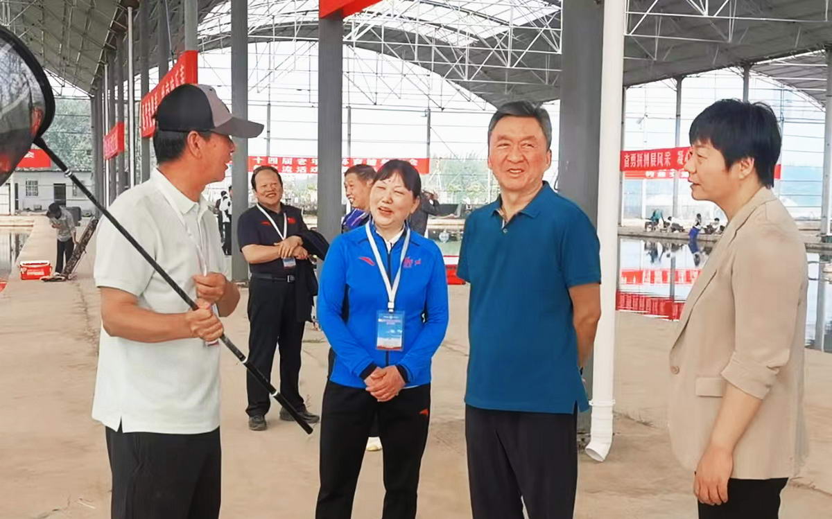河南省老年体协主席王保存（右二）等领导在活动现场与平顶山市运动员王新杰亲切交谈