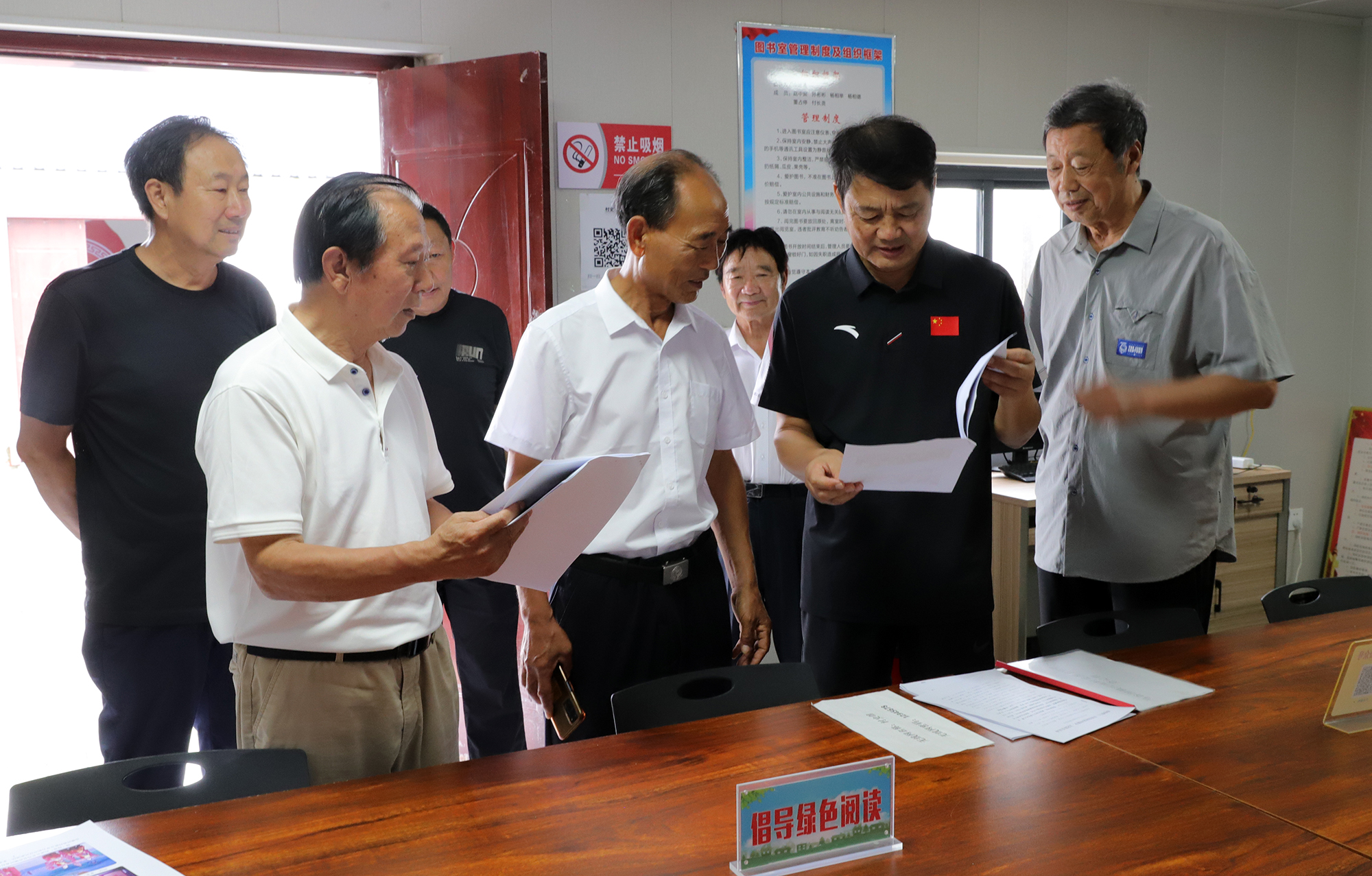 姚新建在泌阳县马谷田镇河南村调研，查看村老年体育工作资料。
