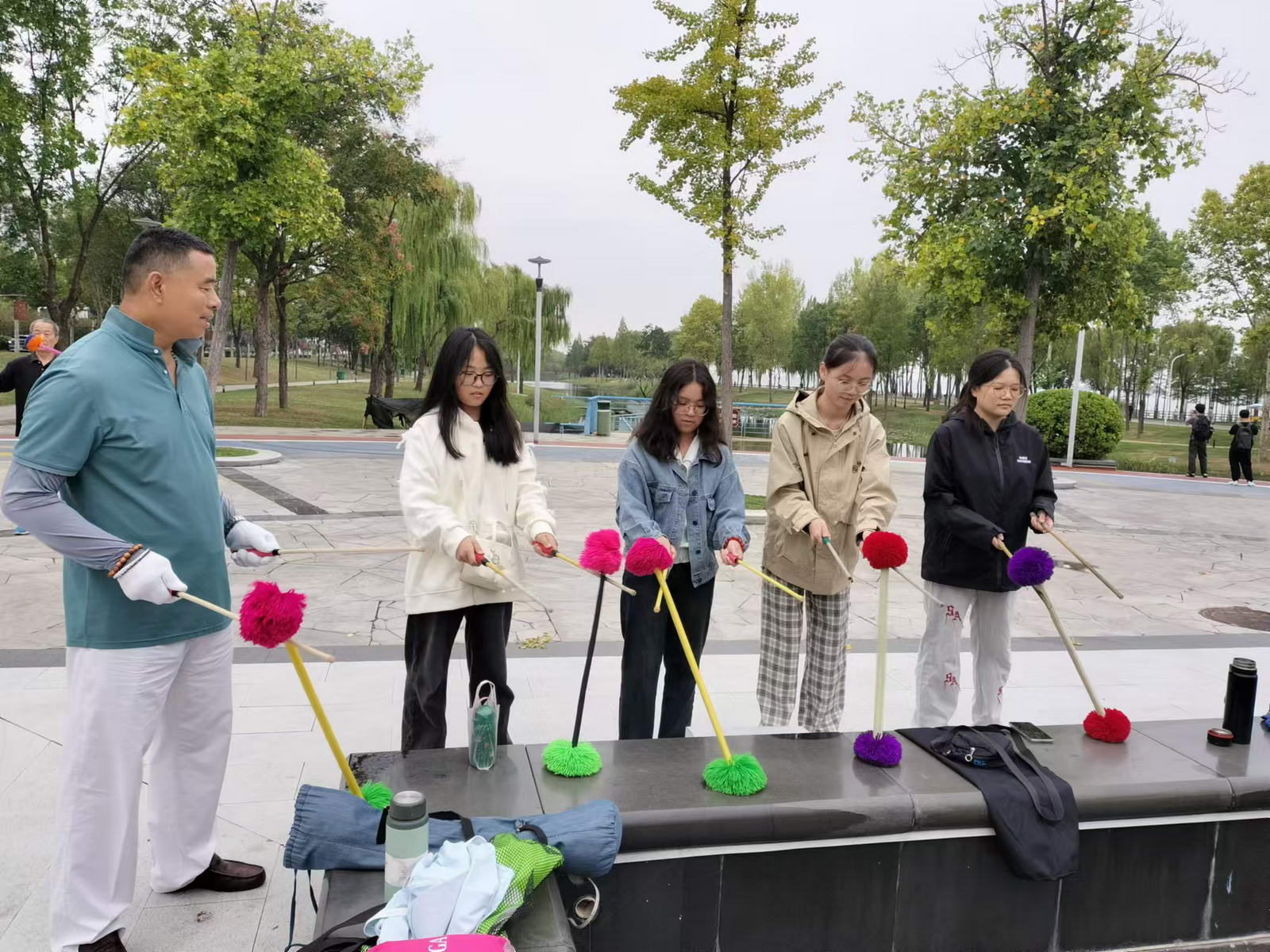 7、刘春华在辅导河南城建学院的学生打花棍。