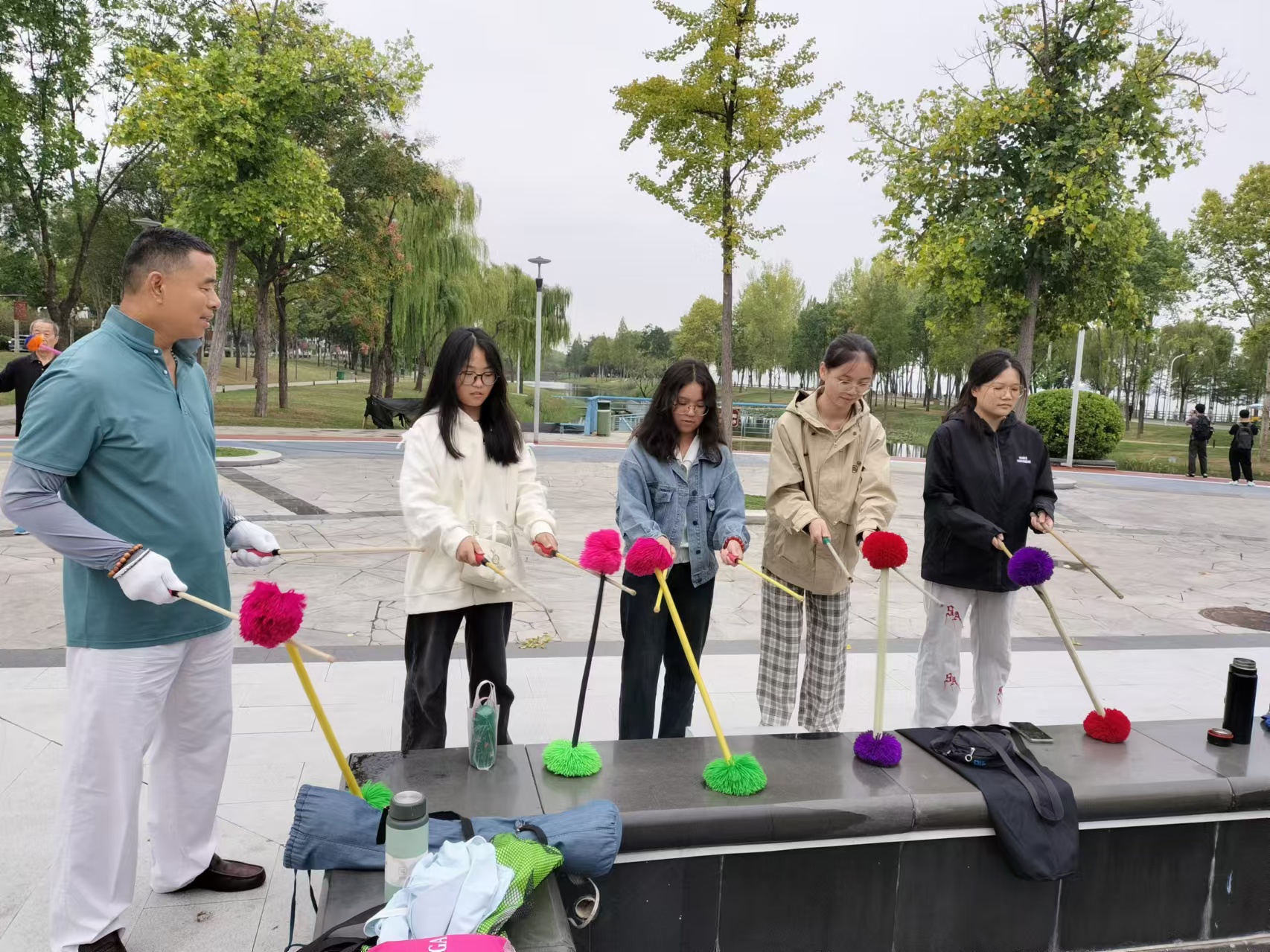 10、花棍队正在辅导河南城建学院的学生打花棍。