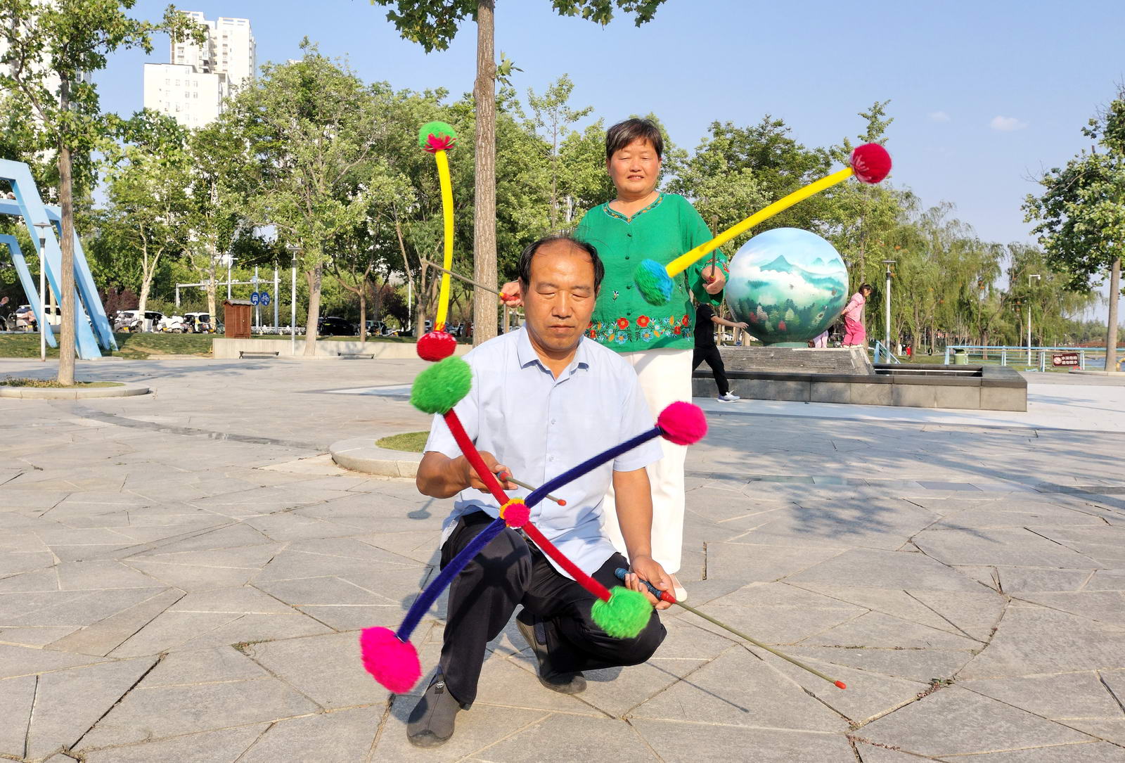 吴少英，63岁；贾黎明，63岁。她们是平顶山花棍队伍建设的开疆拓土者。夫妻俩十分主重发展新队员。几年来，与大家一道组建了龙翔社区花棍队和鹰城广场花棍队。近年来，组织打花棍项目参加社会上各种大型演出活动。让花棍这项＂非遗＂体育项目发扬广大。摄影：孙根生